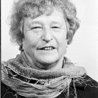 Smiling elderly woman wearing a scarf.