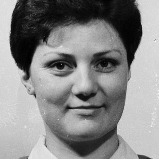 Young woman in a plaid shirt, black-and-white portrait.
