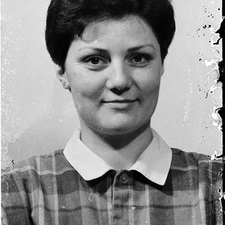 Young woman in a plaid shirt, black-and-white portrait.