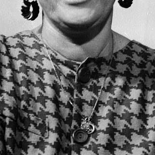 Portrait of smiling woman wearing patterned blouse and large earrings.