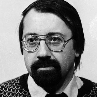 Portrait of a man wearing glasses and patterned sweater.