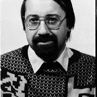 Portrait of a man wearing glasses, sweater, and a beard.