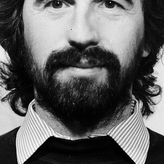 Portrait of a bearded man in black sweater.