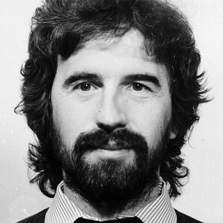 Portrait of a bearded man in black sweater.
