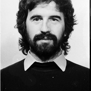 Portrait of a bearded man in black sweater.