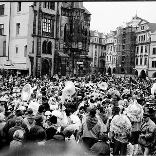 Crowded festive parade in historic European town square.