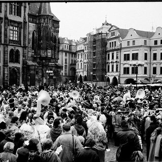 Crowded historic square during festive parade.