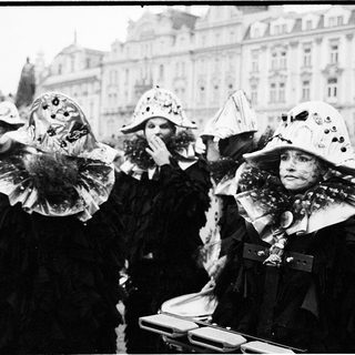 Costumed women in festive hats at parade.