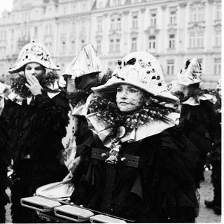 Costumed women in festive hats at parade.