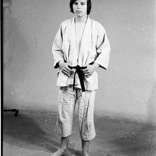 Person in traditional judo attire standing formally.