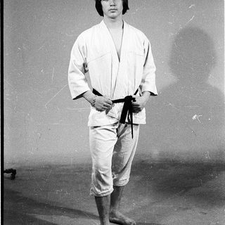 Person wearing traditional judo uniform standing.