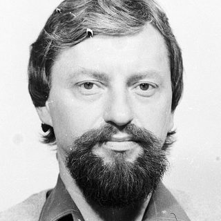 Man with beard and mustache in casual sweater.