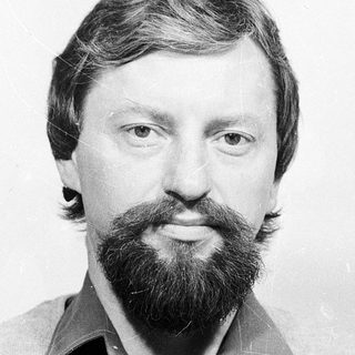 Man with beard and mustache in casual sweater.