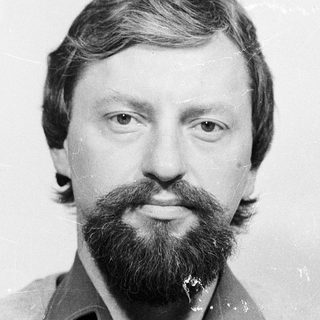 Man with beard and mustache in casual attire.