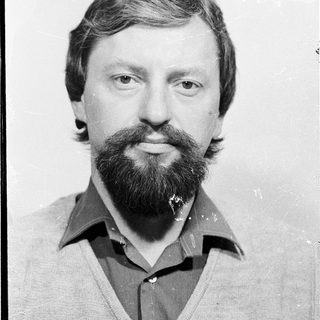 Man with beard and mustache in casual attire.