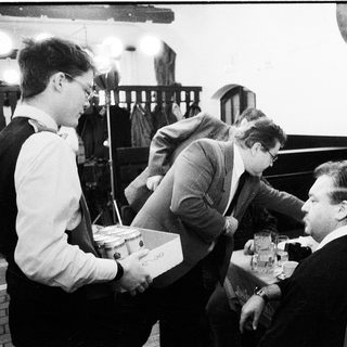 Group of men playing chess in indoor setting.
