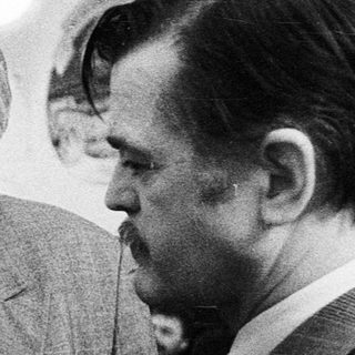Businessmen conversing at an indoor event.