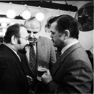 Businessmen conversing at an indoor event.