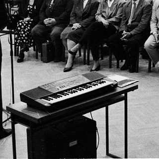 Large audience listens to a speaker at a formal event.