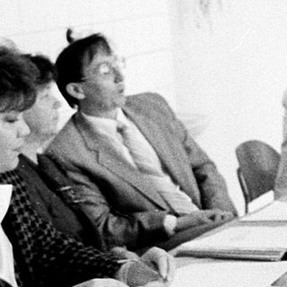 Meeting or conference with attendees seated and standing.