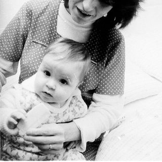 A woman holding and smiling at a baby.