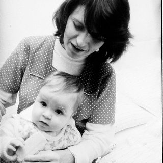 A woman holding and smiling at a baby.