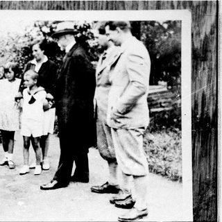 Family group outdoors in vintage clothing, posing together.