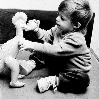 Young child playing with a duck toy.