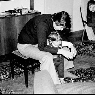 A woman comforting a young child indoors.