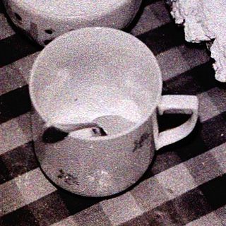 Vintage table with cake, cups, and teapot.