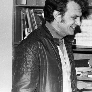 Man smiling in office with filing cabinets.