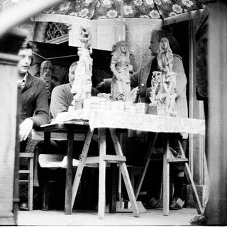 Artisans crafting religious sculptures in workshop.