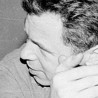 Man sitting with hands covering face.