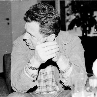 Man sitting with hands covering face.