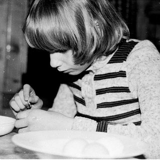 Child decorating a cake with frosting.