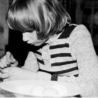 Child decorating a cake with frosting.