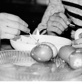 Young girl peeling and cutting boiled eggs.