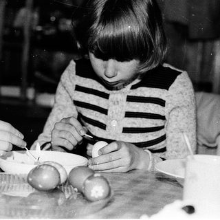 Young girl peeling and cutting boiled eggs.