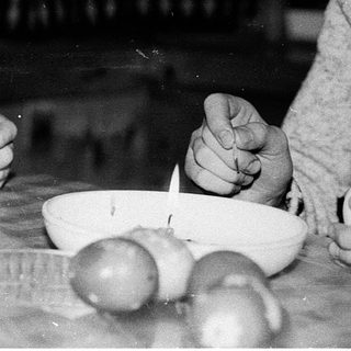Woman peeling vegetables indoors during meal preparation.