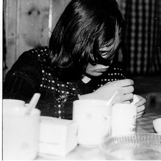 Woman peeling vegetables indoors during meal preparation.