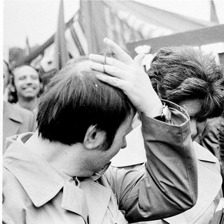 Young men in protest, one being restrained.