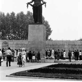Statue of woman holding wreath in memorial park.