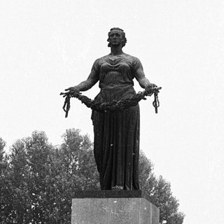 Statue of woman holding wreath in memorial park.