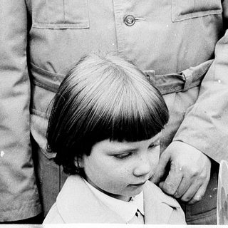 Man holding young child outdoors in 1970s.