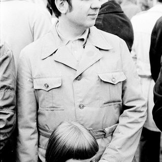 Man holding young child outdoors in 1970s.