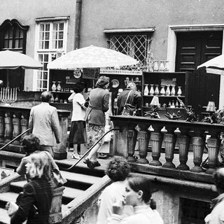 Vintage outdoor market with antique lamps and household items.
