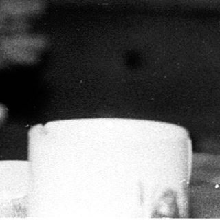 Two children drinking at a table indoors.