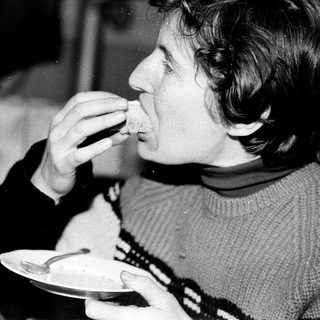 Person eating food indoors at a table.