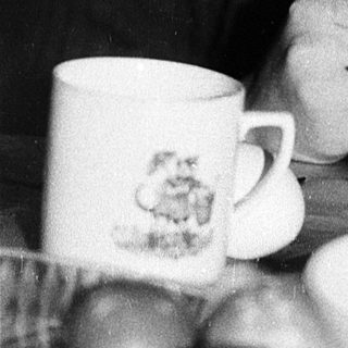 Person eating soup with spoon indoors.