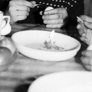 Person eating soup with spoon indoors.